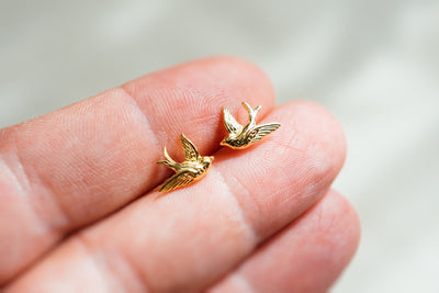 Kleine süße Vogelohrringe. Goldene Schwalben