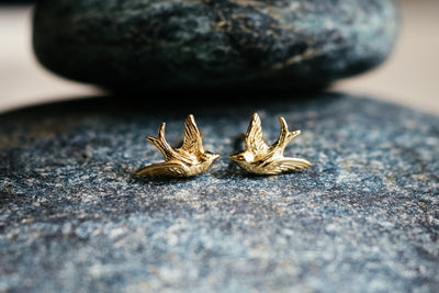 Kleine süße Vogelohrringe. Goldene Schwalben