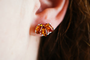 Handmade amber stud earrings featuring marquise-cut Baltic amber set in 925 sterling silver, displayed on a soft neutral background. Dainty, elegant, and perfect for everyday wear or gifting.